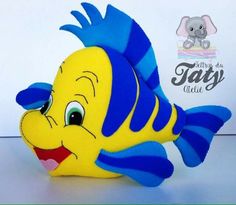 a yellow and blue stuffed fish sitting on top of a table