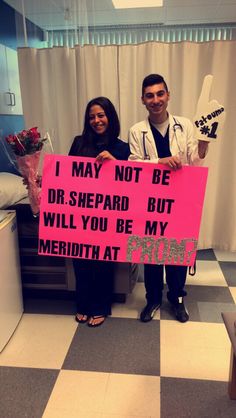 a man and woman standing next to each other holding a pink sign that says, i may not be dr shepard but will you be my meridian at pm