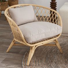 a wicker chair sitting on top of a wooden floor next to a lamp and rug