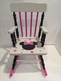 a minnie mouse rocking chair with pink polka dots on the seat and black wooden legs