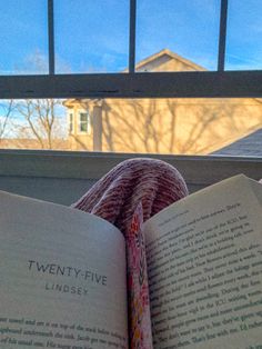 an open book sitting on top of a window sill