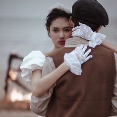 a man and woman embracing each other on the beach