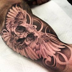 a man's arm with an owl and skull tattoo design on the side of his leg