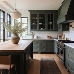 a kitchen with green cabinets and wooden floors