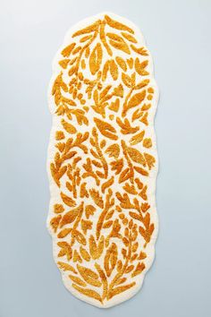 an orange and white rug with leaves on it