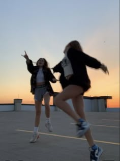 two young women are jumping in the air