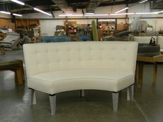 a white couch sitting on top of a wooden table in a room filled with furniture