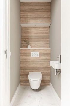 a white toilet sitting inside of a bathroom next to a sink