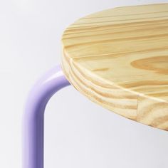 a close up of a wooden table with purple metal legs