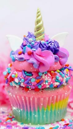 there is a cupcake with sprinkles and a unicorn horn on top