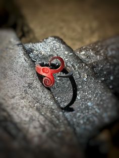 a pair of red scissors sitting on top of a rock