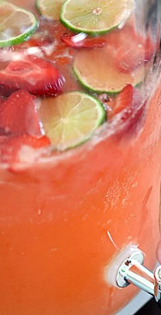 a pitcher filled with fruit and ice on top of a table