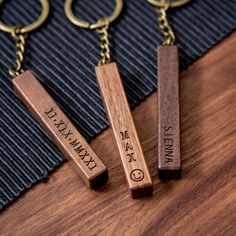 three wooden key chains sitting on top of a table