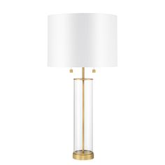 a glass lamp with a gold base and a white lampshade on the side