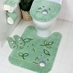 a bathroom with green rugs on the floor next to a toilet and towel dispenser