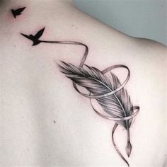 the back of a woman's shoulder with an arrow and feather tattoo on it