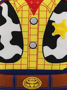 the back side of a toy backpack with a cow pattern on it and a sheriff badge