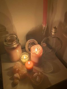 some candles are sitting on a table with other items