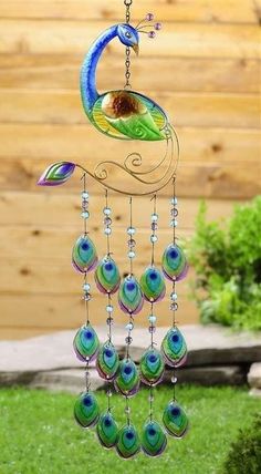 a wind chime hanging from the side of a wooden fence with green and blue beads