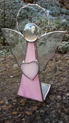 a pink and silver angel holding a heart