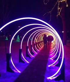 some people are standing in the snow with purple lights