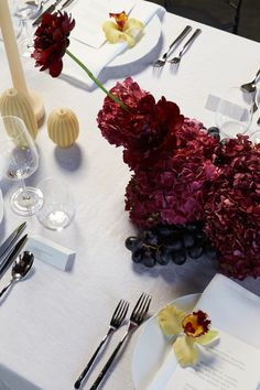 the table is set with flowers and silverware