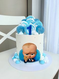 there is a cake that looks like a baby's head with blue decorations on it