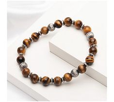 Elevate your laid-back style with this handsome tiger's eye beaded bracelet with stainless steel accents. From Verve. Tiger Eye Beaded Bracelet, Tiger Eye Bracelet Men, Tiger's Eye Bracelet, Men’s Lion Bracelet, Tiger Eye Bracelet, Tiger Eye Beads, Laid Back Style, Tiger Eye, Handmade Bracelets