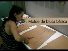 a woman sitting at a table with a piece of paper on top of it that says molde de blusa basica