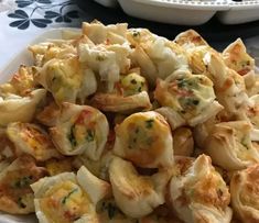 a white plate topped with dumplings covered in cheese