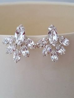 a pair of diamond earrings sitting on top of a table