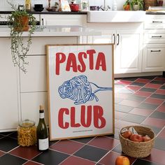 a sign that says pasta club next to some fruit on the floor in a kitchen