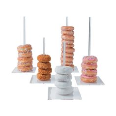 four donuts stacked on top of each other in different shapes and sizes, all with sprinkles