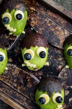 green monster cakes with googly eyes on a baking sheet