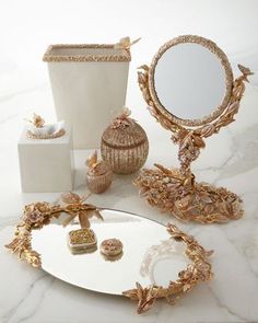 an assortment of decorative items displayed on a marble counter top, including a mirror and vase