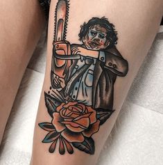 a person with a tattoo on their leg holding a chainsaw and roses in front of them