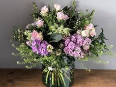 a vase filled with lots of purple and white flowers