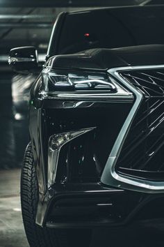 the front end of a black car in a parking garage