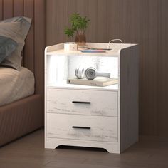 a white night stand with two drawers and a plant in the corner next to it