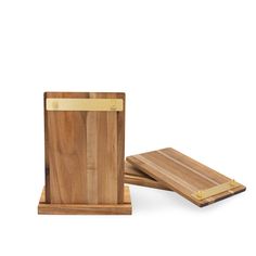 two wooden cutting boards with gold handles on each side and one in the middle, sitting next to each other