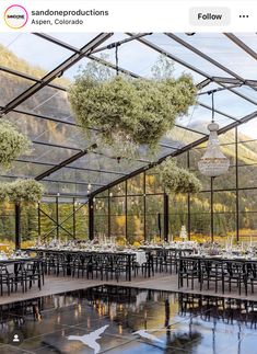 the inside of a building with tables and chairs set up for an outdoor wedding reception