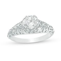 a diamond ring with filigrees on the sides and a center stone in the middle