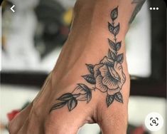 a woman's hand with a flower tattoo on it