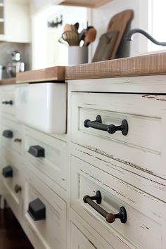 an old kitchen cabinet with knobs and pulls on the drawers in front of it