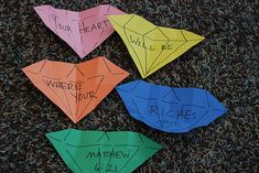 four origami pieces with words written on them sitting in the middle of carpet