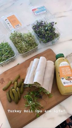 there are many vegetables on the cutting board next to some sauces and other food