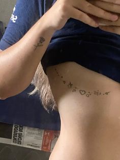 a woman is looking at her cell phone while she has tattoos on her stomach and chest