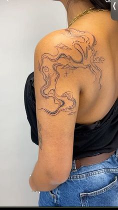 the back of a woman's shoulder with a tattoo on her arm and chest