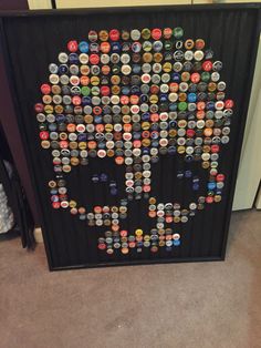 a black frame with a skull made out of many different bottle caps on the front