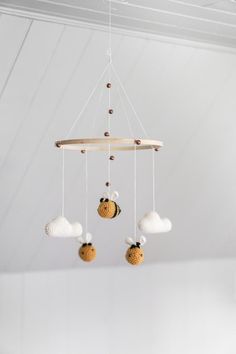 a mobile made out of seashells hangs from the ceiling in a white room